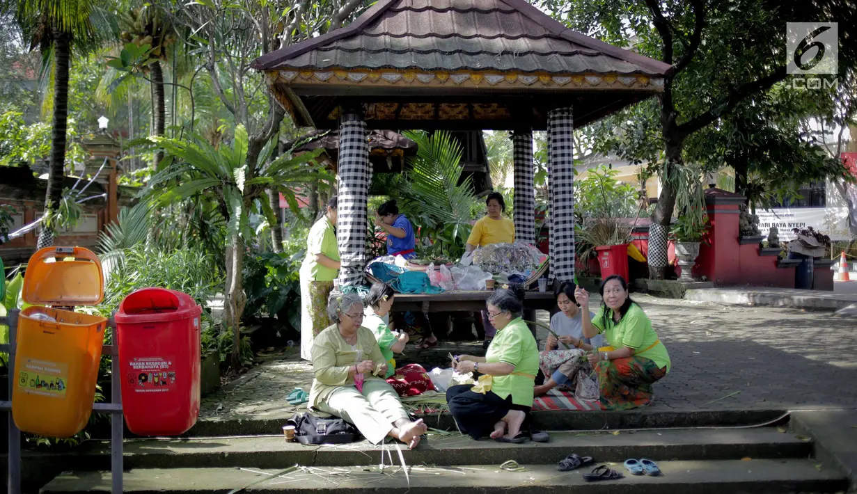 Sejumlah ibu-ibu membuat berbagai macam sesajen untuk persiapan menyambut Hari Raya Nyepi 2019 pada Tahun Baru Saka di Pura Aditya Jaya, Rawamangun, Jakarta, Senin (4/3). (Liputan6.com/Faizal Fanani)