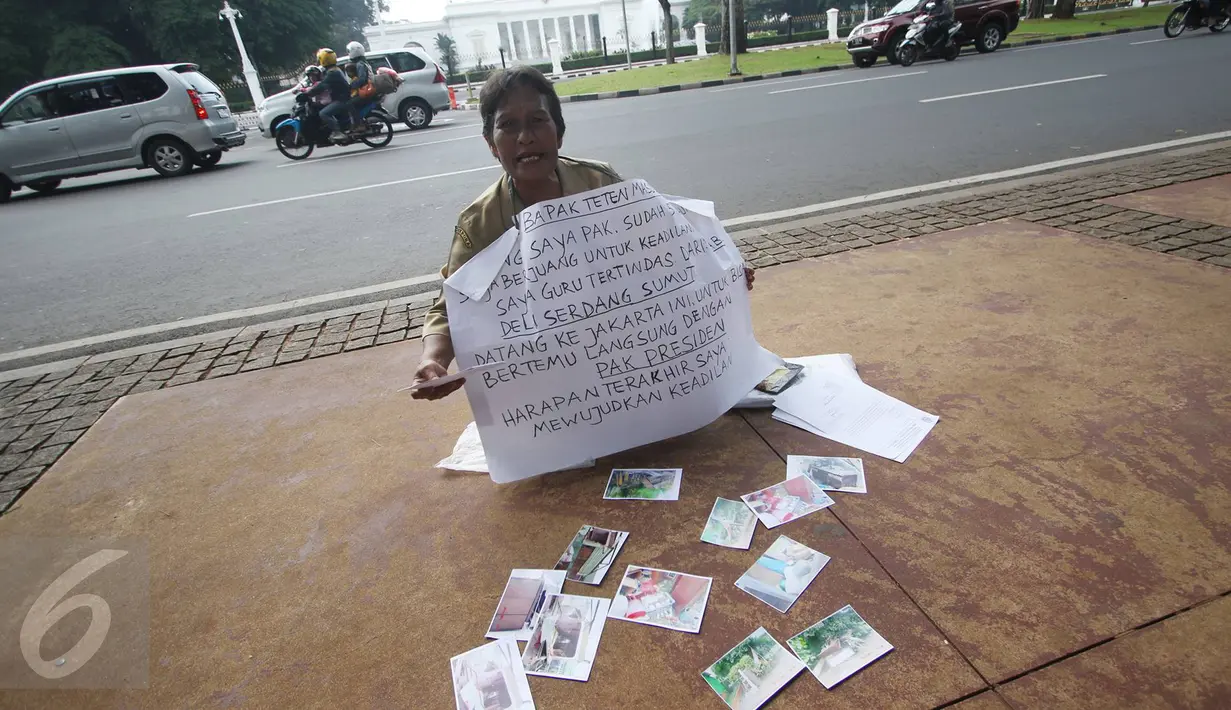 Nelly Hutabarat, guru asal Deli Serdang, Sumatera Utara, melakukan aksi diam di depan Istana Negara, Jakarta, Rabu (13/7). Nelly menuntut keadilan atas penutupan SDN 10-61-59 dan pembongkaran rumah dinasnya pada 2011 silam (Liputan6.com/Immanuel Antonius)