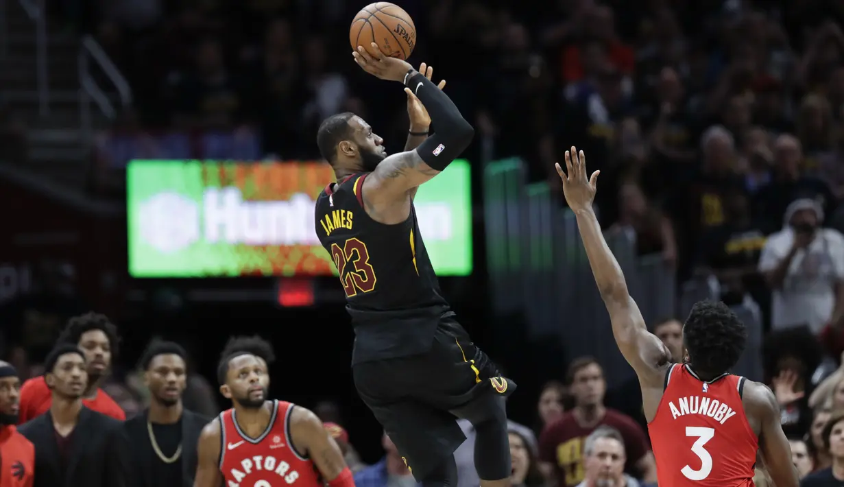 Aksi bintang Cleveland Cavaliers, LeBron James (23) melepaskan tembakan melewati adangan dua pemain Raptors pada gim keempat semifinal Wilayah Timur NBA playoff di Quicken Loans Arena, Cleveland, (7/5/2018). (AP/Tony Dejak)