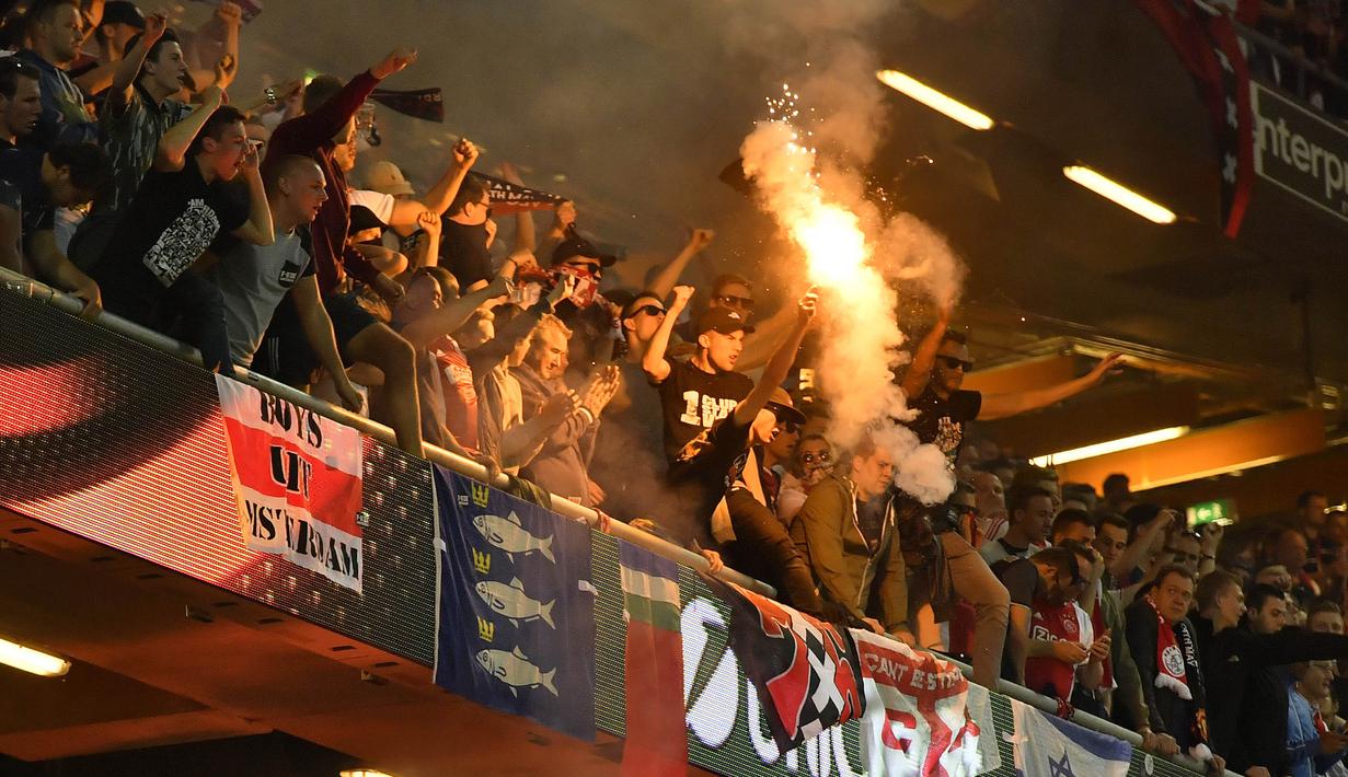 Suporter Ajax Amsterdam menyalakan flare saat menyaksikan langsung tim kesayanganya kalah dari Manchester United di Stadion Stockholm, Swedia, (24/05/2017). Manchester menang 2-0. (AP/Martin Meissner)