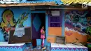 Seorang anak berdiri di depan pintu rumah dengan warna-warni cat dinding dan grafiti di Kampung Bekelir, Babakan Kota Tangerang, Jumat (16/11). Kampung ini dihuni sekitar 300 KK. (Liputan6.com/Fery Pradolo)