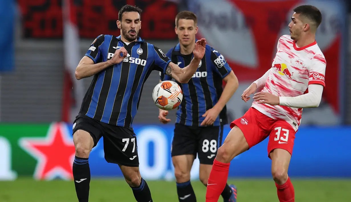 Bek Atalanta Davide Zappacosta (kiri) berebut bola dengan pemain depan RB Leipzig Andre Silva bersaing pada leg pertama perempatfinal Liga Europa di Red Bull Arena, Kamis (7/4/2022). Atalanta bermain imbang 1-1 dengan RB Leipzig. (Ronny HARTMANN / AFP)