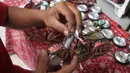 Perajin Ogifson Harianja, menyelesaikan miniatur vespa dari kaleng bekas, Jakarta, Jumat (7/1/2022). Pemerintah melalui Kemenko Perekonomian telah mengumumkan bahwa plafon penyaluran KUR 2022 ditingkatkan menjadi Rp373,17 triliun, dengan suku bunga tetap sebesar 6 persen. (Liputan6.com/Angga Yuniar)