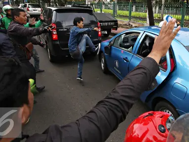 Pengendara ojek online merusak dan melakukan sweeping di kawasan Senayan, Jakarta, Selasa (22/3). Pascabentrok ojek online melakukan sweeping dan perusakan terhadap taksi serta bajaj yang melintas di kawasan tersebut. (Liputan6.com/Immanuel Antonius)