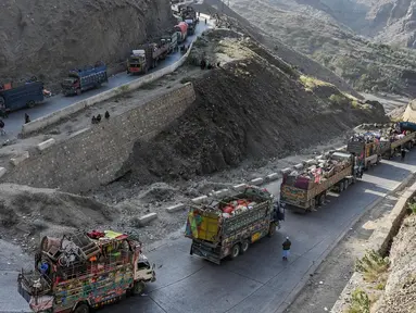 Truk-truk yang mengangkut para pengungsi Afghanistan beserta barang-barang mereka terlihat di sepanjang jalan menuju perbatasan Torkham Pakistan-Afghanistan pada tanggal 3 November 2023. (Abdul MAJEED/AFP)