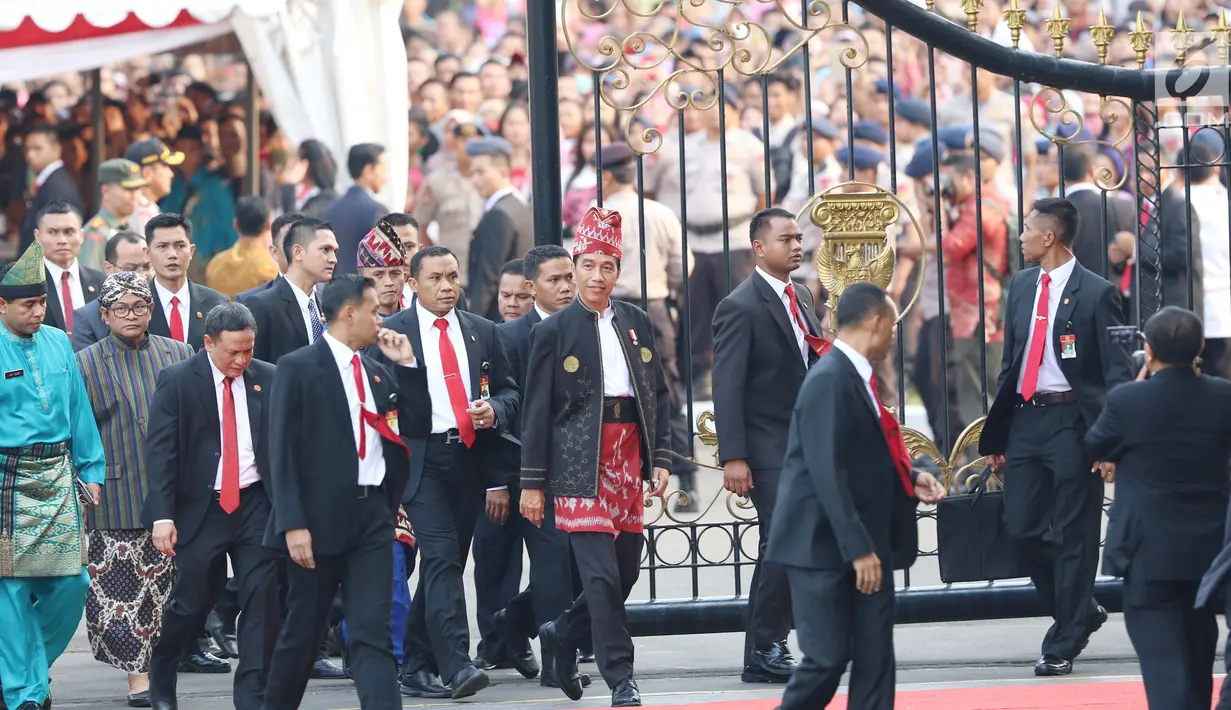 Presiden Joko Widodo atau Jokowi berjalan keluar menuju tribune dekat pagar Istana Merdeka, Jakarta, Kamis (17/8). Jelang penurunan bendera pusaka, Jokowi tiba-tiba keluar dan menemui masyarakat yang berdiri di luar Istana. (Liputan6.com/Angga Yuniar)