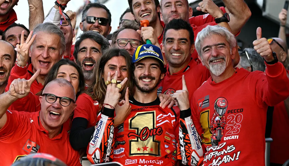 <p>Francesco Bagnaia, merayakan keberhasilan dirinya sebagai juara dunia MotoGP 2023 bersama pujaan hati dan seluruh satf Ducati setelah finis posisi pertama pada balapan MotoGP Valencia hari Minggu (26/11/2023). (AFP/Javier Soriano)</p>
