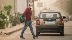 Seorang pejalan kaki yang mengenakan masker berjalan di sebuah jalan di Kairo, Mesir, pada 5 April 2020. Mesir pada Sabtu (4/4) melaporkan lima kematian baru akibat infeksi COVID-19, menjadikan total kasus kematian di negara tersebut mencapai 71. (Xinhua/Wu Huiwo)
