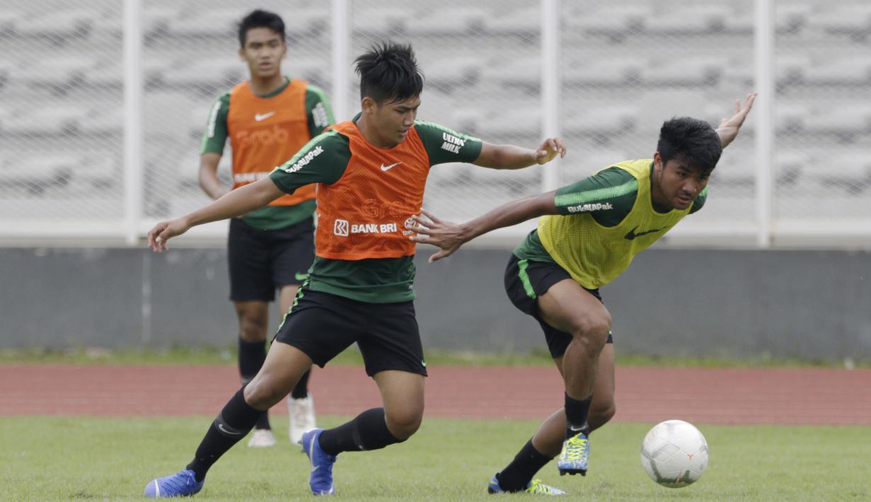 Pemain Timnas Indonesia U-22, Asnawi Mangkualam, berebut bola dengan Witan Sulaeman saat latihan di Stadion Madya, Jakarta, Jumat (18/1). Latihan ini merupakan persiapan jelang Piala AFF U-22. (Bola.com/Yoppy Renato)