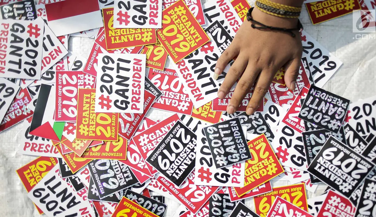 Pedagang menjajakan stiker #2019GantiPresiden saat berlangsungnya Car Free Day di kawasan Bundaran HI, Jakarta, Minggu (29/4). Pedagang banyak meraup untung dari penjualan kaus dan atribut bertagar #2019GantiPresiden. (Liputan6.com/Faizal Fanani)