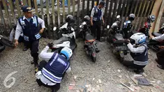 Petugas Dishub mencabut pentil kendaraan roda dua dalam operasi penertiban parkir liar di Pusat, Jumat (23/10/2015). Meskipun informasi penertiban diduga telah bocor, ratusan kendaraan yang parkir liar tetap ditertibkan. (Liputan6.com/Immanuel Antonius)