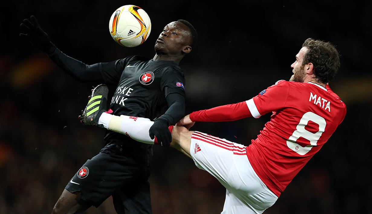 Pemain Midtjylland, Pione Sisto, berebut bola dengan gelandang Manchester United, Juan Mata. Meski pada leg pertama MU takluk 1-2, namun berhasil lolos karena menang 5-1 di kandang. (EPA/Nigel Roddis)