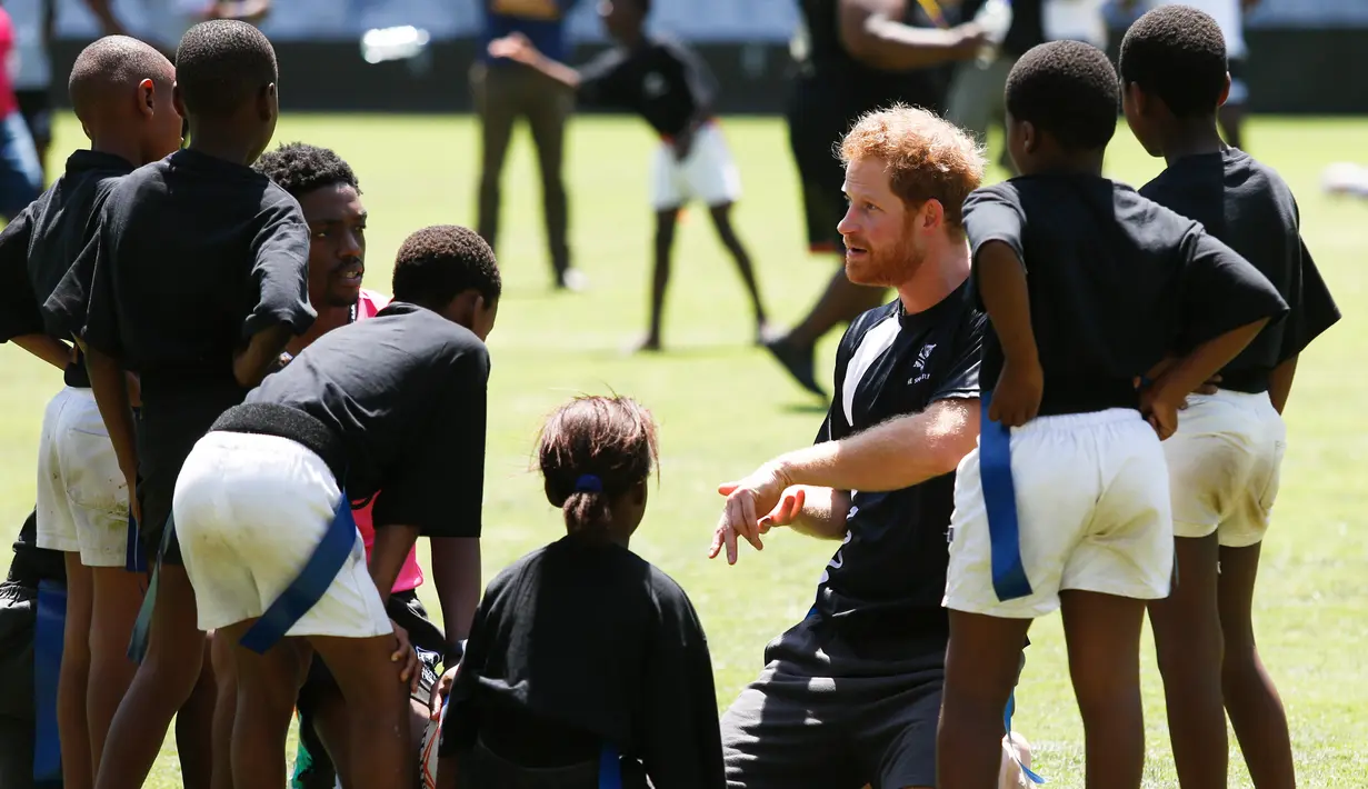 Pangeran Harry  berbincang dengan anak - anak di Durban , Afrika Selatan, Selasa (1/12). Harry dan  Pangeran Lerotholi Seeiso membuat organisasi amal yang bernama Sentebale. (REUTERS/Rogan Ward) 