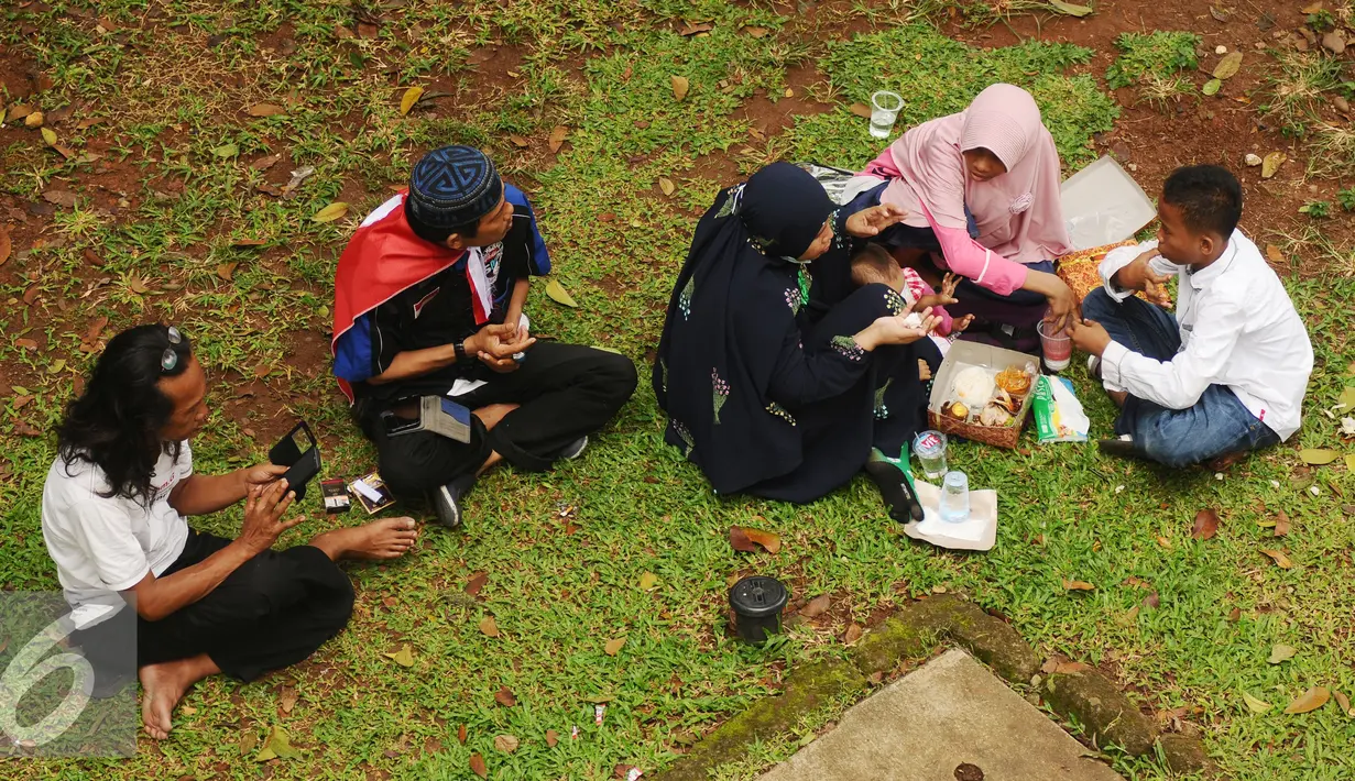 Massa aksi damai berkumpul makan di pinggirJalan Merdeka Barat, Jakarta, Jumat (4/11). Massa melakukan aksi di depan Istana Negara menuntut penegakan hukum kasus dugaan penistaan agama. (Liputan6.com/Helmi Fithriansyah)