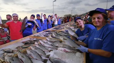 Anggota dari Lebanon's Batroun Traders Association memegang ikan yang berhasil memecahkan rekor makanan laut terbanyak di daerah kota pantai Batroun, Minggu (4/9). Menurut panitia, total ikan yang dikumpulnya sebanyak 2 ton 614 kg. (AFP PHOTO/Anwar AMRO)