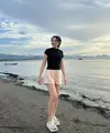 Bermain di pantai, Happy Asmara tampil dengan atasan kaos hitam ketat dipadukan celana pendek warna peach dan sandal karet putihnya.  (@happy_asmara77)