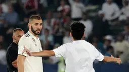 Seorang fans menghampiri striker Real Madrid, Karim Benzema selama pertandingan semifinal Piala Dunia Antarklub 2018 antara Real Madrid melawan Kashima Antlers di stadion Zayed Sports City di Abu Dhabi, Uni Emirat Arab (19/12). (AFP Photo/Giuseppe Cacace)