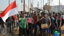 Sejumlah warga berhasil mengambil hadiah pada lomba Panjat Pinang Kolosal dalam rangka merayakan HUT RI ke-70 di Pantai Karnaval, Ancol, Jakarta, Senin (17/8). Sebanyak 124 batang pinang disediakan dengan beragam hadiah. (Liputan6.com/Herman Zakharia)