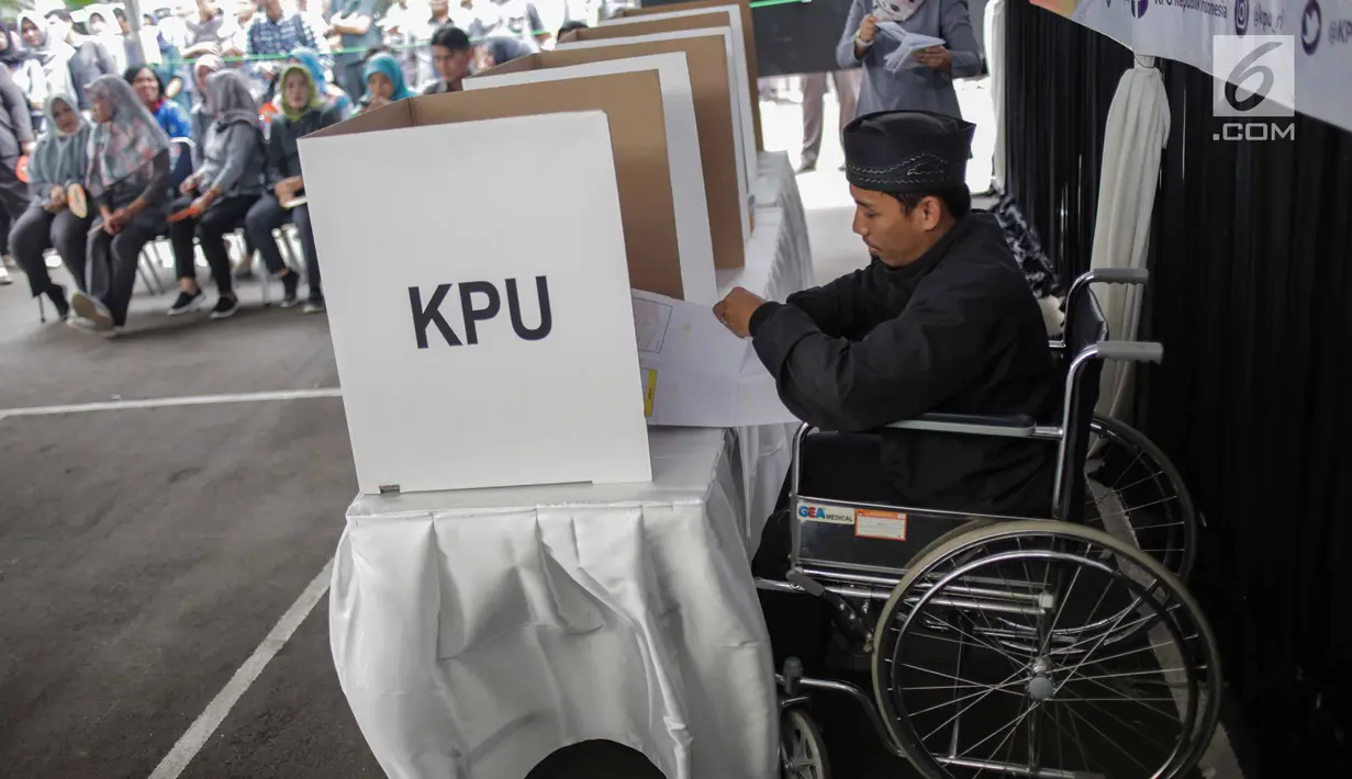 Penyandang disabilitas melakukan pencoblosan saat ikut simulasi pemungutan dan penghitungan suara Pemilu 2019 di halaman Gedung KPU, Jakarta, Selasa (12/3).  Simulasi untuk merepresentasikan pemungutan suara seperti di TPS. (Liputan6.com/Faizal Fanani)