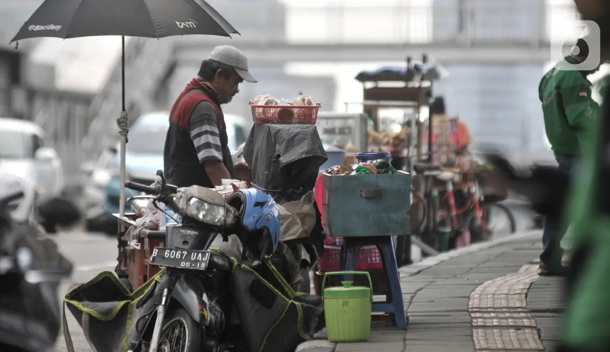 Pedagang asongan beraktivitas tanpa mengenakan masker di kawasan Cawang, Jakarta, Rabu (8/4/2020). Organisasi Kesehatan Dunia (WHO) telah merekomendasikan agar menggunakan masker saat berada di tempat umum demi memutus mata rantai penyebaran virus Corona. (merdeka.com/Iqbal Nugroho)