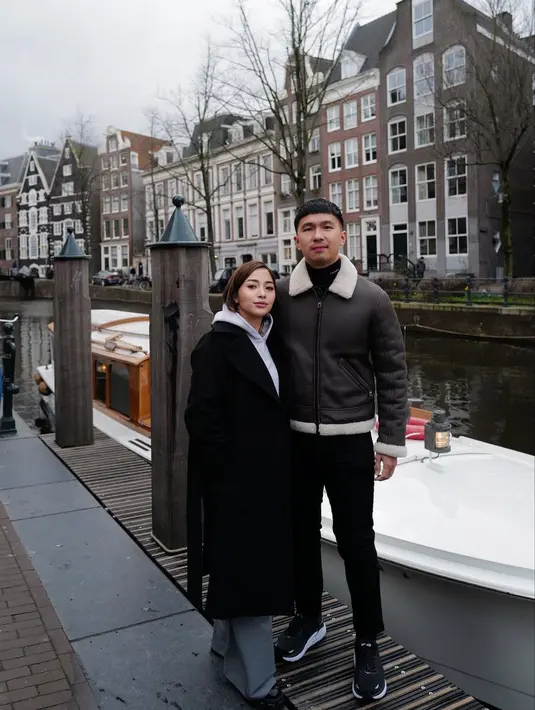 Nikita Willy dan Indra Priawan tampil dengan winter look. Nikita dengan long coat hitam, sedangkan Indra memadukan penampilannya dengan jaket kulit. [Foto: Instagram/nikitawillyofficial94]