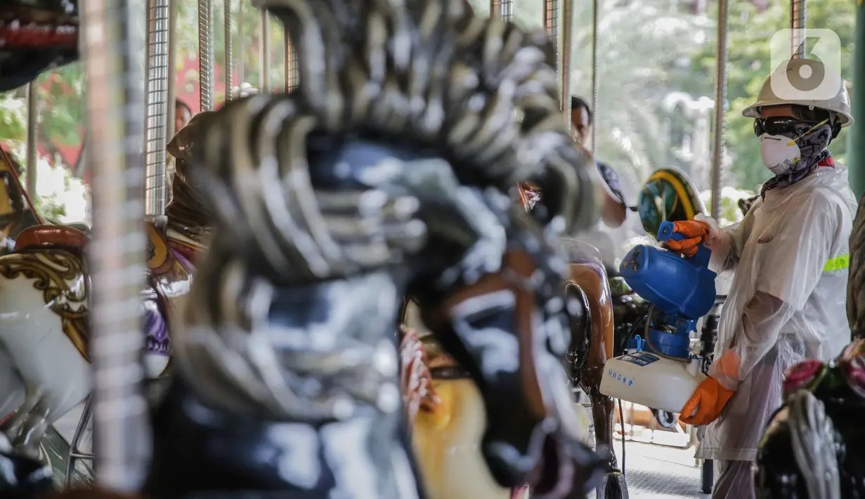 Petugas mengenakan pakaian pelindung menyemprotkan disinfektan wahana komidi putar di Dufan, Ancol, Jakarta, Sabtu (14/3/2020). Penutupan sementara untuk unit rekreasi Taman Impian Jaya Ancol sejak Sabtu, 14 Maret 2020 sampai 27 Maret 2020. (Liputan6.com/Faizal Fanani)