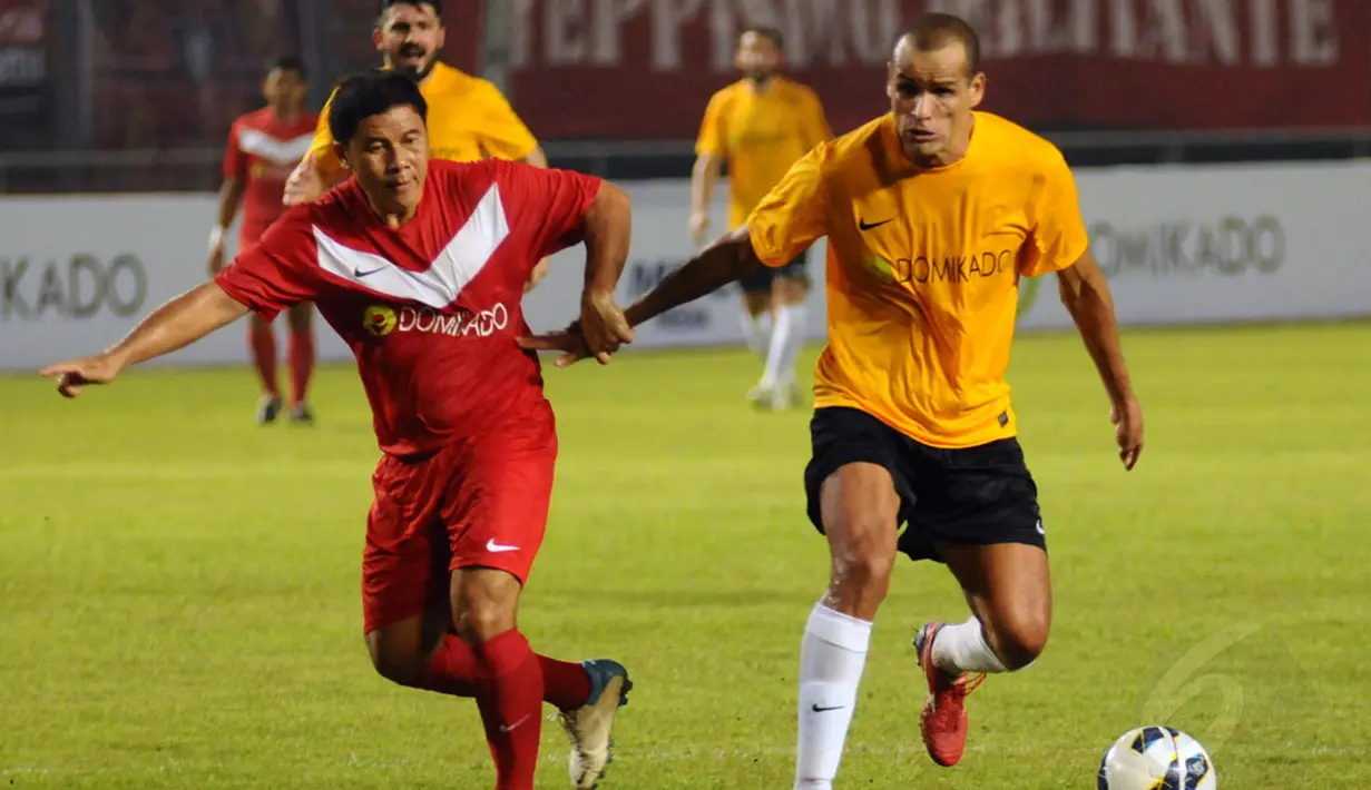 Mantan pemain Timnas Brasil, Rivaldo (kanan) berhasil lolos dari kawalan pemain Legenda Indonesia di Stadion GBK Jakarta,  (Liputan6.com/Helmi Fithriansyah)