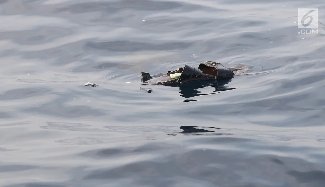 Sandal mengambang di laut pascajatuhnya pesawat Lion Air JT 610 di laut utara Tanjung Pakis, Jawa Barat, Senin (29/10). Pesawat Lion Air JT 610  yang jatuh di Karawang buatan tahun 2018. (Liputan6.com/Herman Zakharia)
