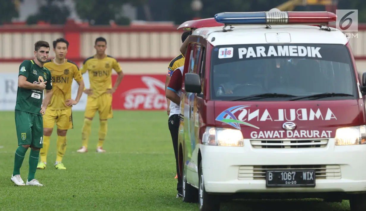 Ambulan mengevakuasi pemain Persebaya, Andri Muladi saat laga melawan Bhayangkara FC pada lanjutan Go-Jek Liga 1 Indonesia bersama Bukalapak di Lapangan PTIK, Jakarta, Rabu (11/7). Laga berakhir imbang. (Liputan6.com/Helmi Fthriansyah)