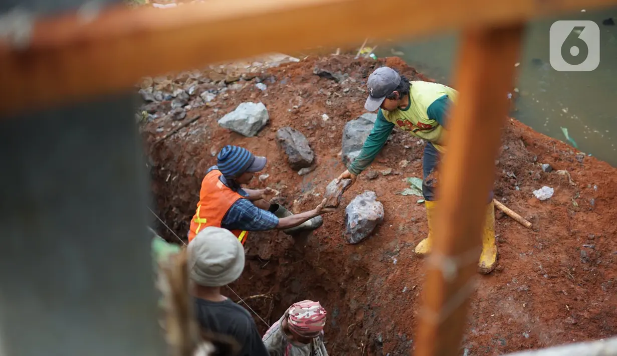 Pekerja menyelesaikan pembangunan turap di dinding Kali Tanah Baru, Depok, Jawa Barat, Kamis (3/12/2020). Pembangunan turap dilakukan guna mencegah tanah longsor yang terjadi di sejumlah titik di sepanjang bantaran Kali Tanah Baru tersebut. (Liputan6.com/Immanuel Antonius)