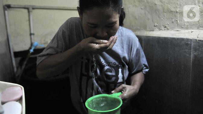 Warga mencium air PAM yang masih keruh dan berbau di Kampung Baru Kubur Koja, Penjaringan, Jakarta, Minggu (6/10/2019). Sudah hampir dua pekan air PAM di permukiman warga RT 04, 05, 07, dan 08 RW 15 Kampung Baru Kubur Koja keruh dan berbau. (merdeka.com/Iqbal S Nugroho)