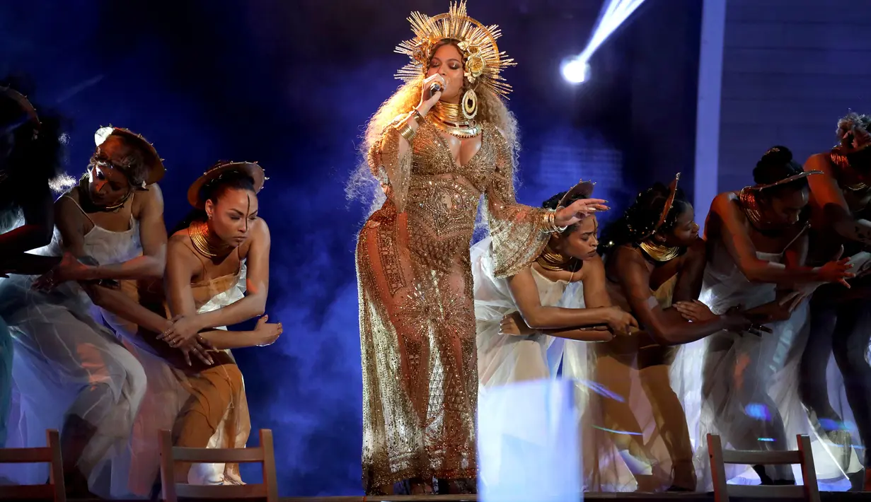 Penyanyi Beyonce ditemani puluhan penari latar di atas panggung Grammy Awards 2017 di Staples Center, Los Angeles, Minggu (12/2). Melengkapi penampilannya, Beyonce juga mengenakan hiasan kepala emas, yang terlihat mewah. (Photo by Matt Sayles/Invision/AP)