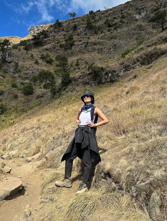Saat mendaki, Tatjana melepas jaketnya untuk diikat di pinggang-nya. Ia tampak kece dengan sleeveless top, bucket hat, dan kacamata hitamnya. [@tatjanasaphira]