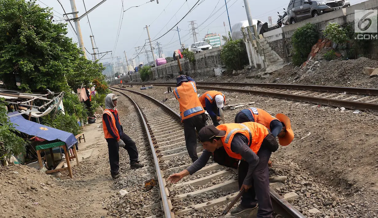 Pekerja menambahkan kerikil pada bantalan rel kereta di kawasan Roxy, Jakarta, Selasa (7/1). Penambahan kerikil tersebut dilakukan sebagai bentuk perawatan rutin agar perjalanan kereta tetap aman dan lancar. (Liputan6.com/Immanuel Antonius)