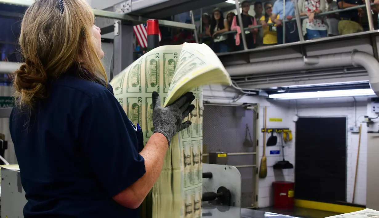 Pekerja menimbang paket lembaran 20 USD yang baru dicetak di Biro Pengukiran dan Percetakan AS, Washington, Amerika Serikat, Jumat (20/7). (Eva HAMBACH/AFP)