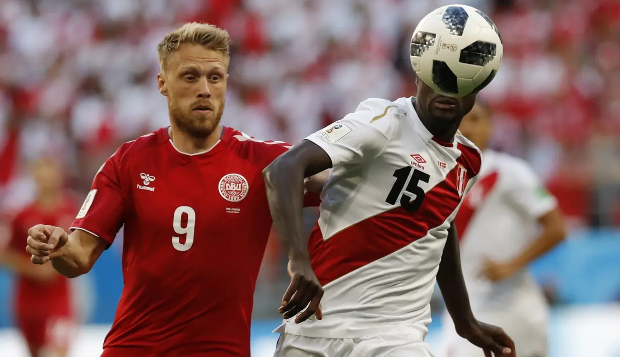 Bek Peru, Christian Ramos, berebut bola dengan striker Denmark, Nicolai Jorgensen, pada laga Grup C Piala Dunia di Mordovia Arena, Saransk, Sabtu (16/6/2018). Denmark menang 1-0 atas Peru. (AP/Efrem Lukatsky)