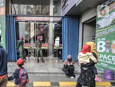 Anggota TNI berjaga di salah satu pintu masuk Blok B Pasar Tanah Abang, Jakarta, Minggu (2/5/2021). Petugas gabungan TNI, Polri, dan Satpol PP memperketat penjagaan di tiap pintu masuk Blok A dan B Pusat Grosir Tanah Abang guna mencegah kerumunan pengunjung. (merdeka.com/Iqbal S Nugroho)