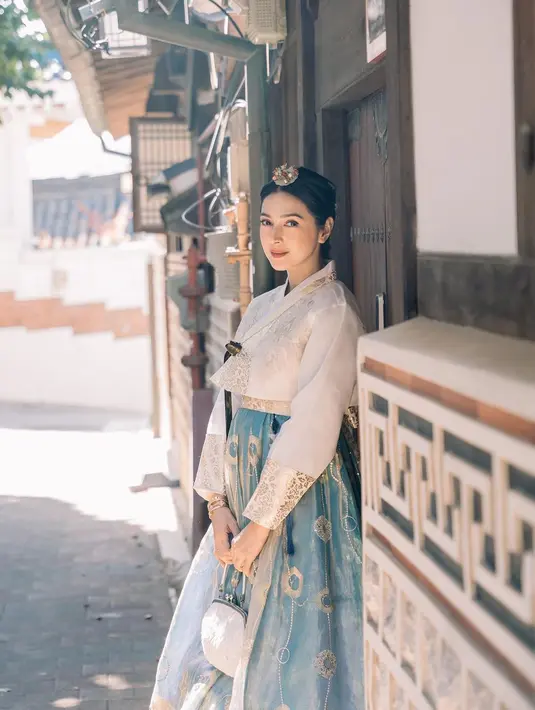 Ia menjinjing hand bag putih dengan headpiece bunga yang terlihat manis [@nsyakieb85]