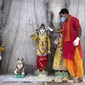 Seorang pendeta membersihkan patung Dewa Siwa dan dewa-dewa Hindu lainnya di sebuah kuil di Prayagraj, India, Senin (8/6/2020). India kembali membuka tempat ibadah, pusat perbelanjaan, dan restoran setelah tiga bulan lockdown karena pandemi virus corona COVID-19. (AP Photo/Rajesh Kumar Singh)