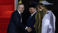 Perdana Menteri Australia Anthony Albanese (kiri) tersenyum setibanya di Bandar Udara Internasional Halim Perdanakusuma di Jakarta pada 14 Mei 2025. (YASUYOSHI CHIBA/AFP)