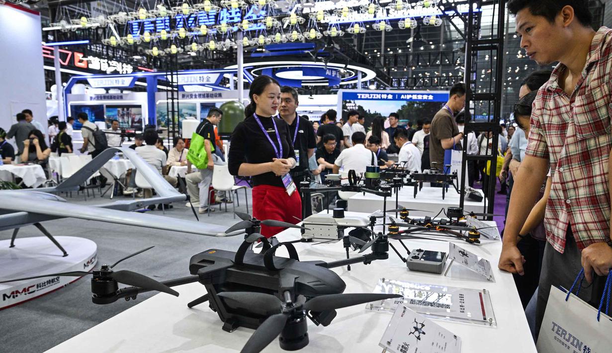 Orang-orang mengunjungi stan Micro Multi Copter (MMC) selama Drone World Congress (DWC) di Shenzhen pada 21 Mei 2026. (HECTOR RETAMAL/AFP)