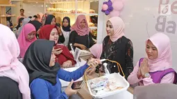 Aktris Laudya Cynthia Bella saat melayani pembeli di sela-sela kunjungan ke toko roti di kawasan Depok, Jawa Barat (30/10). Dalam kesempatan ini Bella juga ikut membantu melayani pembeli di toko roti miliknya. (Liputan6.com/Herman Zakharia)