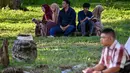 Orang-orang berdoa untuk kerabat mereka yang meninggal dunia dalam peristiwa gempa dan tsunami Aceh pada 2004 lalu di sebuah kuburan massal di Siron, pada 26 Desember 2025. Hari ini, Jumat (26/12/2025), peringatan 21 tahun tragedi gempa dan tsunami Aceh 2004 tetap digelar. (CHAIDEER MAHYUDDIN/AFP)