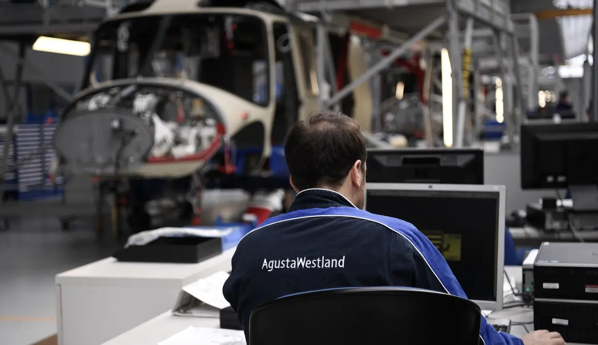 Karyawan perusahaan Leonardo Helicopters memeriksa kondisi helikopter saat merakit AgustaWestland AW189 di Vergiate, dekat Milan, Italia, Selasa (30/1). AgustaWestland AW189 merupakan helikopter sipil bermesin ganda. (MARCO BERTORELLO/AFP)