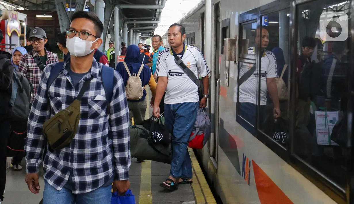 Penumpang Kereta Api Jarak Jauh (KAJJ) berjalan setibanya di Stasiun Pasar Senen, Jakarta, Sabtu (5/4/2025). (Liputan6.com/Herman Zakharia)