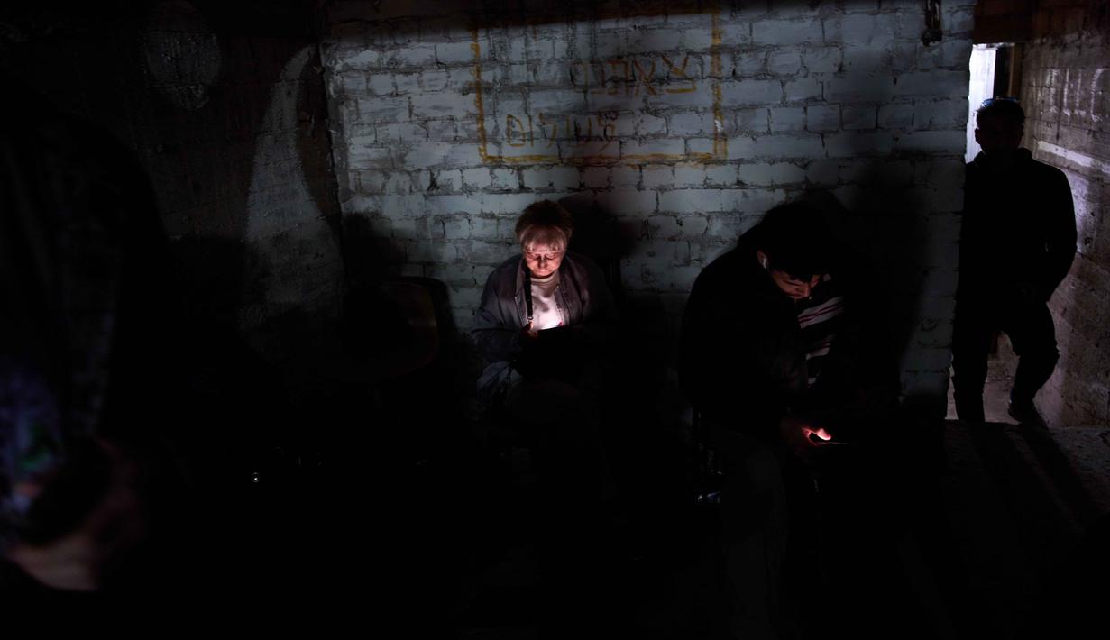 Sirene peringatan adanya serangan udara kembali meraung di Ramat Gan dan wilayah Israel Tengah lainnya. Tampak dalam foto, warga berlindung di tempat perlindungan bom saat sirene serangan udara memperingatkan akan datangnya serangan rudal Iran di Ramat Gan, Israel, Rabu, 25 Maret 2026. (AP Photo/Oded Balilty)