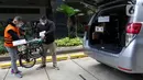 Tersangka Harry van Sidabuke (kiri) menyerahkan sepeda Brompton kepada perantara anggota Komisi II DPR Ihsan Yunus, Agustri Yogasmara saat rekonstruksi perkara dugaan korupsi pengadaan bantuan sosial penanganan COVID-19 di gedung KPK, Jakarta, Rabu (10/2/2021). (Liputan6.com/Helmi Fithriansyah)