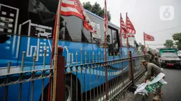 Satu per satu bendera partai politik ditertibkan oleh petugas Satpol PP. (Liputan6.com/Faizal Fanani)
