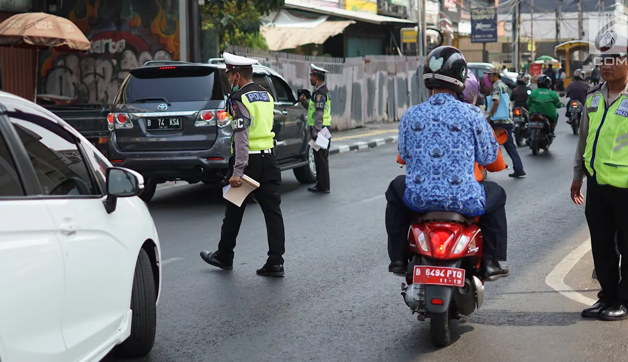 Petugas Kepolisian memberhentikan mobil berplat nomor genap yang memasuki persimpangan Jalan Dharmawangsa X dan Jalan Fatmawati, Jakarta, Senin (9/9/2019). Polisi mulai menindak pengendara yang melanggar perluasan ganjil genap di Jakarta Selatan. (Liputan6.com/Immanuel Antonius)
