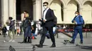 Warga memakai masker berjalan di Milan, Italia (24/2/2020). Kepala Departemen Perlindungan Sipil sekaligus Komisaris Luar Biasa untuk Darurat Coronavirus, Angelo Borrelli mengatakan enam orang meninggal dan 222 lainnya teruji positif infeksi COVID-19 di Italia. (Xinhua/Daniele Mascolo)